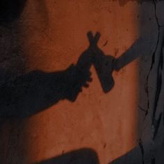 the shadow of a person's hand on a wall