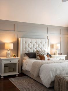 a white bed sitting in a bedroom next to two nightstands with lamps on them