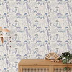 a wallpaper with elephants and giraffes is shown in this room setting