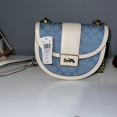 Coach Brand New Light Blue And White. Designer Light Blue Bag With Gold-tone Hardware, Blue Crossbody Bag With Dust Bag Included, Designer Light Blue Bag With Detachable Strap, Chic Light Blue Satchel With Removable Pouch, Designer Blue Satchel With Adjustable Strap, Designer Light Blue Bags With Detachable Strap, Designer Light Blue Shoulder Bag With Detachable Strap, Designer Blue Satchel Shoulder Bag, Blue Coach Bag With Branded Hardware