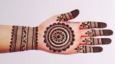 a woman's hand with henna tattoos on it and an intricate design in the middle