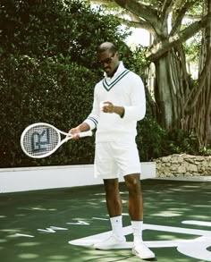 a man holding a tennis racquet standing on top of a tennis ball court