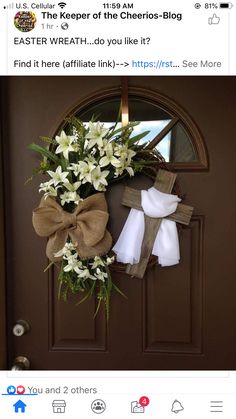 an easter wreath is hanging on the front door with white flowers and burlocks