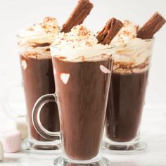 three glasses filled with hot chocolate and marshmallows