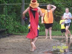 some kids are playing in the water and one is wearing a costume