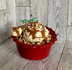 an ice cream sundae with nuts and chocolate drizzled on the top