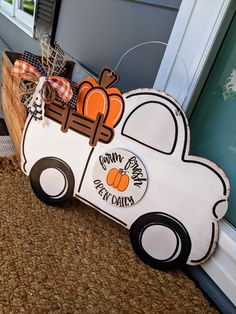 a wooden sign that says happy pumpkin day daisies on the side of a house