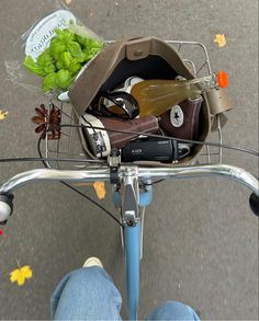 a person riding a bike with a basket full of items on the handlebars