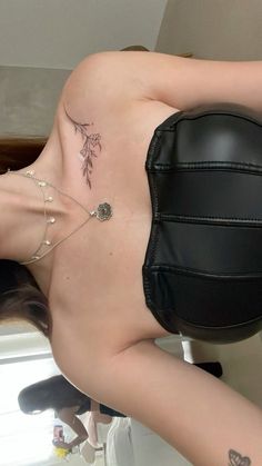 a woman with tattoos on her back laying on a chair