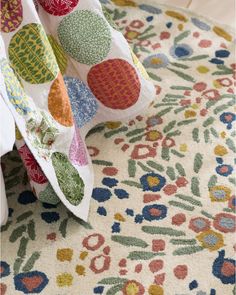 a close up of a rug on the floor with many different colors and shapes in it