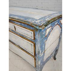 an old blue and white dresser with peeling paint