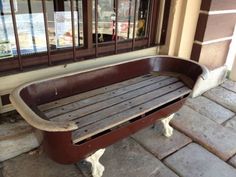 an old wooden bench sitting in front of a building with bars on the window sill