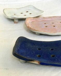 three ceramic skateboards sitting on top of a white sheet covered ground with holes in them