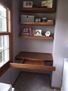 a desk and shelves in a small room