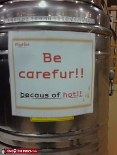 a large metal barrel with a sign on it that says be careful because of hot