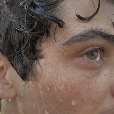 a close up of a man's face with wet hair on top of his head