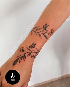 a woman's foot with flowers and leaves tattoo on the left side of her leg