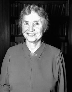 a woman standing in front of a bookshelf with a smile on her face