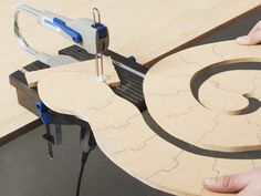 a person using a circular saw to cut out a piece of wood on a table