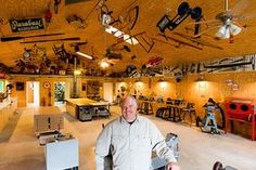 a man is standing in the middle of a room with lots of tools on it