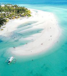 an aerial view of people on the beach and in the water near a small island