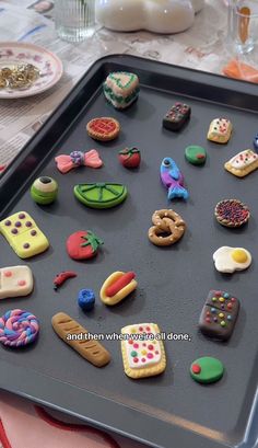 a tray filled with lots of different types of decorated cookies on top of a table