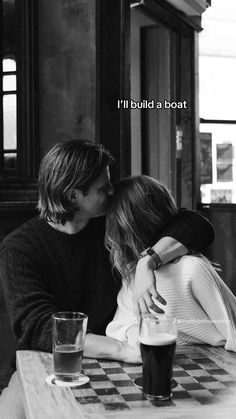 two people sitting at a table kissing each other with the words i'll build a boat above them