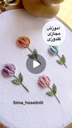 an embroidery project with flowers on it and the words sima hoesiniti written in arabic