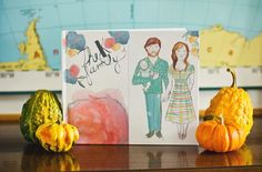 two pumpkins are sitting on a table next to a card