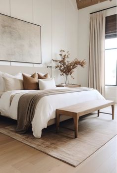 a large bed sitting in a bedroom on top of a wooden floor next to a window