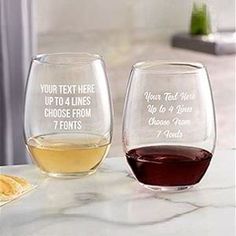 two wine glasses sitting on top of a counter next to each other with different types of wine in them