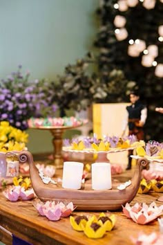 a table topped with lots of food next to a cake and cupcakes on top of it