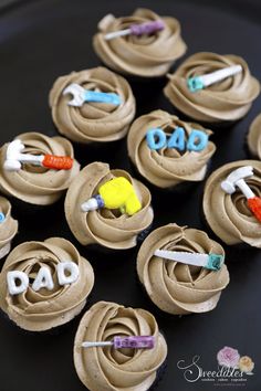 chocolate cupcakes decorated with icing and the words dad spelled out on them