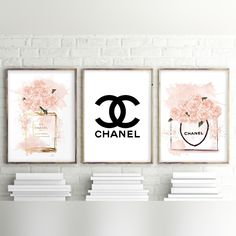 three chanel posters are hanging on the wall next to some books and vases