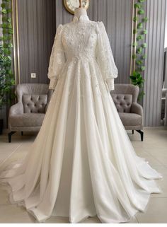 a white wedding dress on display in a room