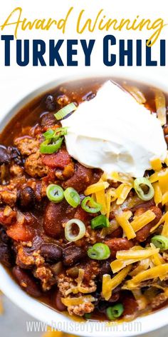 a white bowl filled with turkey chili and sour cream