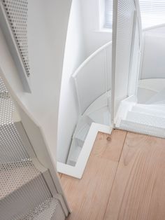 the interior of a house with wooden floors and white walls, looking down at stairs