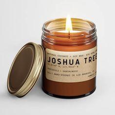 a candle that is sitting next to a jar with a label on the front and side