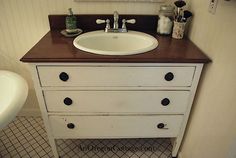 a white sink sitting next to a bath tub in a bathroom