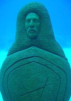 a man's head in the shape of a statue under water with blue background