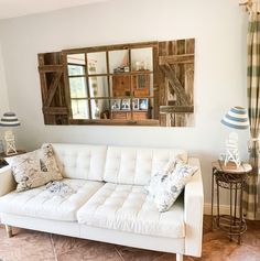 a living room with a white couch and two lamps on the side of the wall