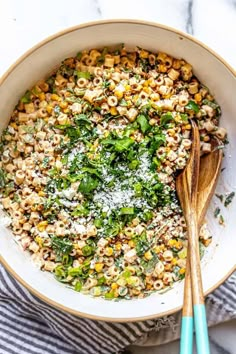 a bowl filled with corn, spinach and parmesan sprinkles