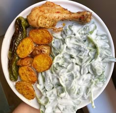 a white plate topped with chicken, potato wedges and green beans covered in ranch dressing