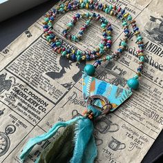 * this was such a joy to create! I knotted a beautiful array of Czech glass beads on Irish waxed Linen to catch the colors in the faux tin focal piece by jewelry artist Humblebeads. The focal has a tribal style display of feathers and butterflies. Below the focal, I added a nice fringe section made with Sari silk.  * Necklace is 28 inches long, pendant is 3 to 4 inches * Designed in Poestenkill NY * NOTE: Wearing in water or to the gym is not recommended  * NOTE:  As with most jewelry , do not force an adjustment if a section becomes mis-aligned. Just give a gentle tug or wiggle and it will straighten out easily. * DISCLAIMER: other items used in photo are not for sale, nor are they included in any purchase. Handmade Multicolor Amulet Jewelry, Multicolor Handmade Amulet Jewelry, Multicolor Beaded Amulet Jewelry, Tibetan Necklace Bohemian, Faux Tin, Turquoise Hand-strung Amulet Beaded Necklace, Talisman Necklace, Artisan Necklace, Sari Silk