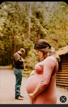 a pregnant woman standing next to a man