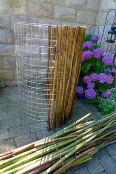 two baskets made out of bamboo sitting next to each other on the ground near flowers