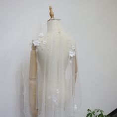 a mannequin wearing a white dress with flowers on it