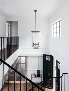 an open staircase leading up to the second floor in a white room with black railings