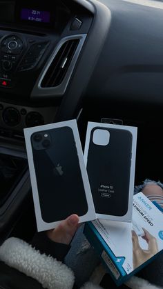 someone is holding up their new iphone case in the back seat of a car with its box open