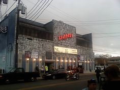 people are walking on the street in front of a building with a sign that says stardust